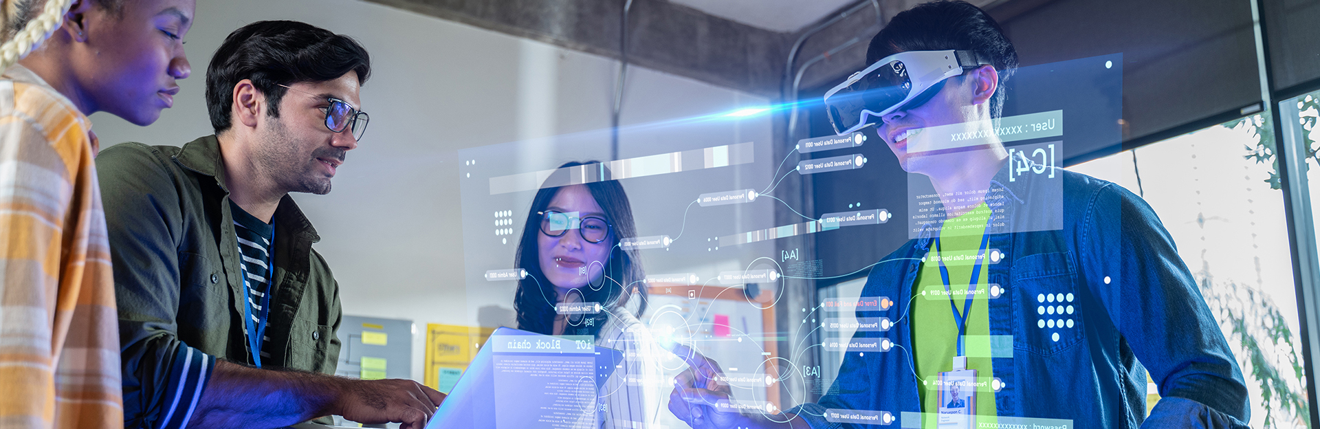Innovative researchers in a high-tech room testing AI technology. One of the researchers is wearing a headset over their eyes and there is a projection screen showing the programming screen he is looking at.