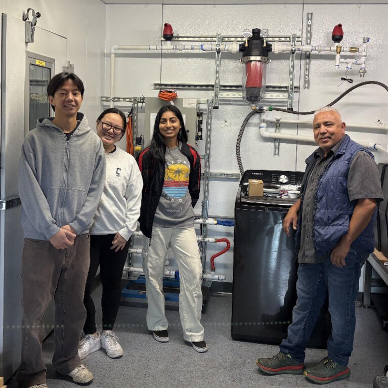 UCR engineering students worked alongside Laundry to Landscapes co-founder Miguel Cuellar to install the company's graywater filtration prototype, preparing the system for testing under real household laundry conditions.
