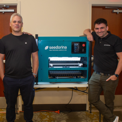 Co-founder of Seedorina Pablo Rodrigo standing beside Seedorina's invention, the Seedbot